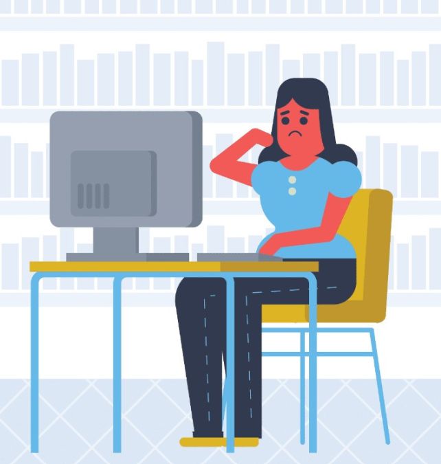 Een bezorgd uitziende vrouw zit voor een computer in een kantoor met een boekenkast op de achtergrond
